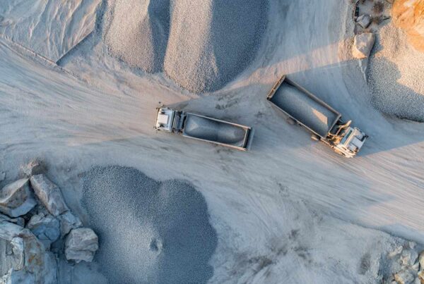 Aerial view of trucks loading gravel at a quarry site for bulk granite supply.