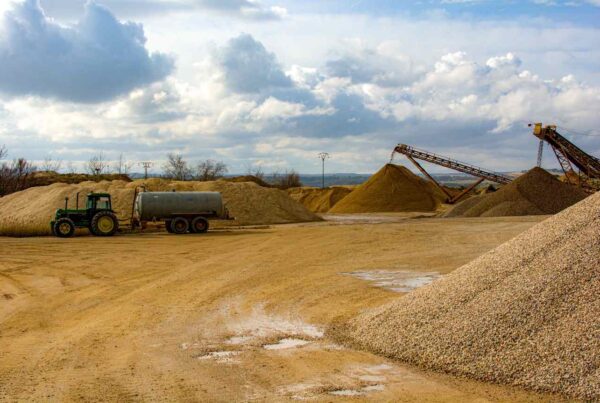Aggregate quarry with piles of crushed rock and processing equipment
