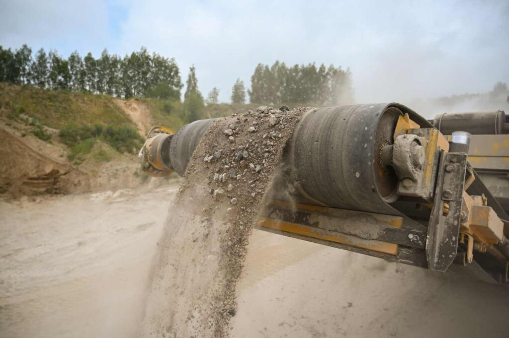 Crushed aggregate moving along a conveyor at a rock quarry