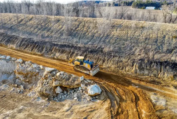Road grader preparing a construction site for bulk rock delivery.